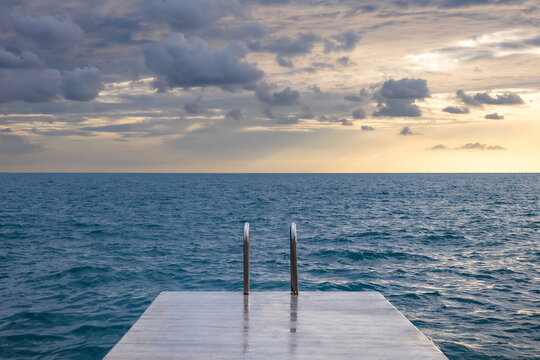 scenic view of calm sea with concrete pier with metal handrails. calm sea background. nature pool. summer vacation concept. minimalistic - Powered by Adobe