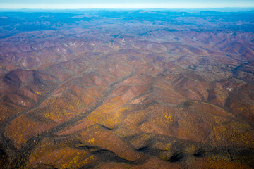 Aerial view. Golden autumn in Primorsky Krai. The Sikhote-Alin mountain range from above.