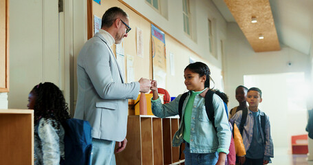 Teacher, children and fist bump greeting at school for welcome to classroom for education. Encourage, smile or group of kids with happy man for learning, scholarship and morning in hallway at academy