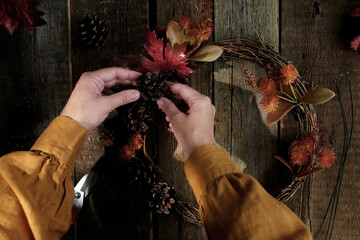 DIY fall wreath. Woman making rustic autumn decoration for thanksgiving day