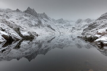 Obraz premium Snowy mountains reflected in a calm lake