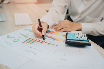 Detailed Analysis of Business Performance with Data Charts and Calculators in Modern Office Setting