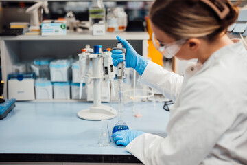 Scientist working with pipette and beaker in laboratory analysis