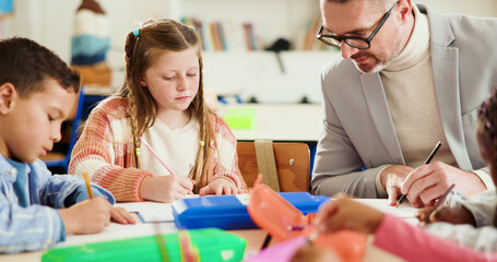 Classroom, teacher and writing with children, education or helping students with task in...