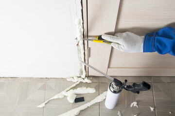 On the floor there is a can of foam and scraps from the installation of the door frame