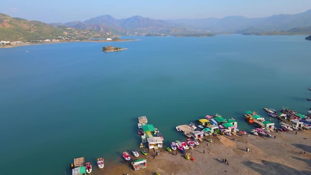 Aerial view of boats docked by the clear turquoise water of Khanpur Lake, with a backdrop of mountains, Khanpur Lake, Khyber Pakhtunkhwa, Pakistan.