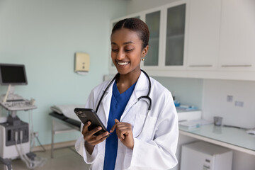 African female nurse in uniform using medical apps on smartphone