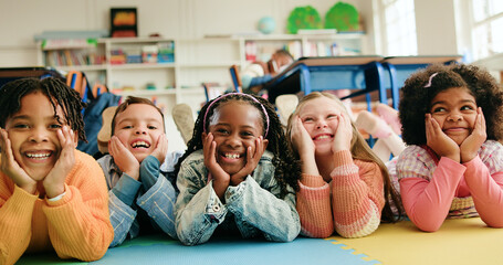 Classroom, happy kids and students on floor for learning, diversity or elementary school. Children, boys and group of girls laugh with friends for education, future development or smile with portrait