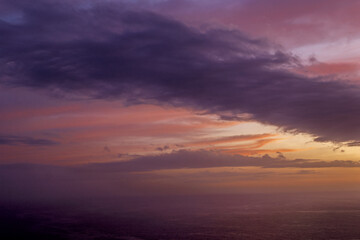 Olympos, Karpathos, Greece, a hillside village at sunset, illuminated path with mountain landscape in the background.