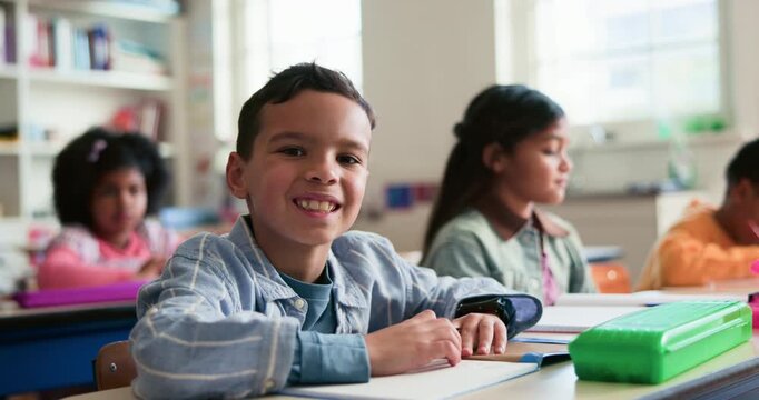 Smile, education and face of child in classroom at elementary school with confidence for learning. Happy, student and portrait of boy kid with pride for assessment at academic lesson at campus.