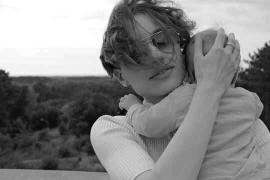 Loving mother hugs her little baby outdoors