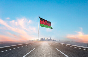 Malawi national flag with mast waving with beautiful skyline. A view from highway. Malawi flag for...