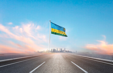 Rwanda national flag with mast waving with beautiful skyline. A view from highway. Rwanda flag for...