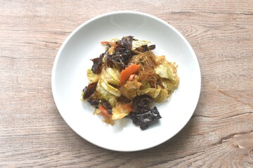 fried glass noodles with black ear mushroom and cabbage in black sweet soy sauce on plate