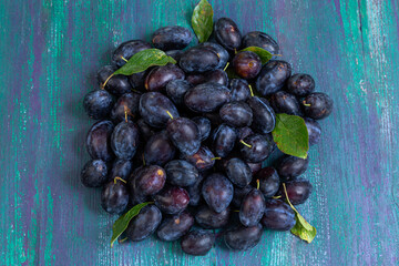 Fresh plums gathered on a rustic wooden surface
