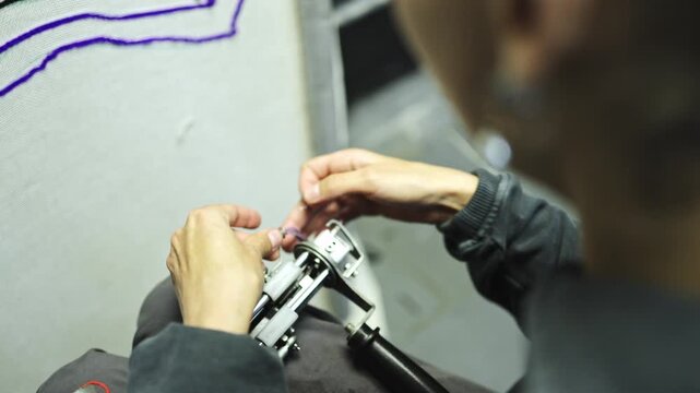 African american craftswoman refilling thread in rug tufting gun 