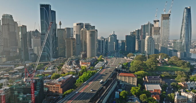 Australia, Sydney: Aerial view Sydney's urban landscape with skyscrapers, bridge road cars, highway traffic, and green spaces reflecting modern city architecture skyline in background. Drone