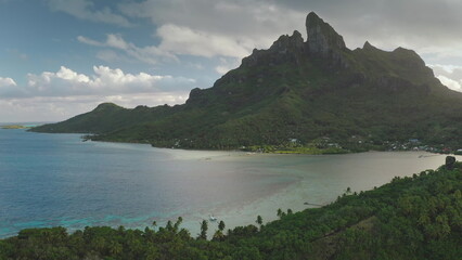Majestic mount otemanu dominates bora bora island's skyline, its verdant slopes meeting the...