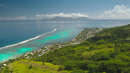 Stunning beauty of Tahiti island hills covered by lush green vegetation, vibrant turquoise lagoon coral reef, and majestic Moorea island. Remote wild nature paradise, exotic summer travel. Aerial