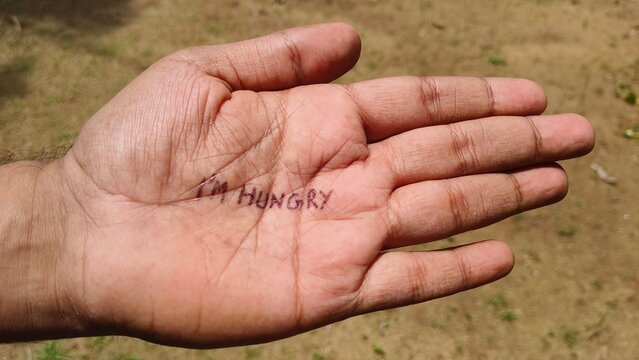 I'm hungry word or text written on starving poor refugee or homeless adult person palm. Hunger, poverty, ravenous, starving, famin, starvation, food crisis and begging concept.