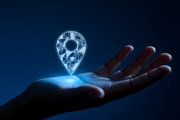 Hand holding a glowing polygonal location pin on a dark blue background with soft lighting effects