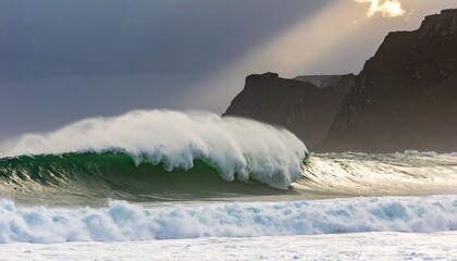 Powerful ocean waves crashing against a rocky shore at sunrise
