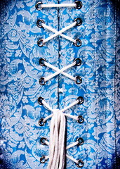 Close-up of a blue corset with white lacing