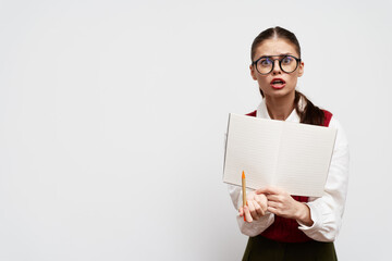 surprised student holding a notebook with a pencil, looking confused, wearing glasses, minimalist background, white color, emphasizing education and curiosity in learning