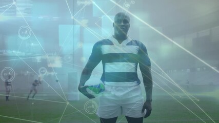 Animation of network of connections over african american male rugby player standing on sports field - Powered by Adobe