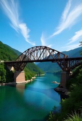 Obraz premium Old railway bridge over a wide river in a green valley