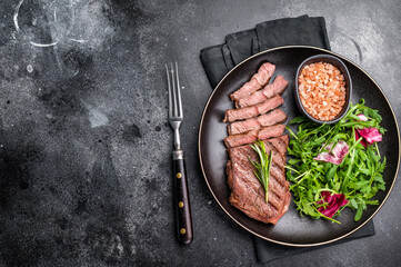 Grilled Top blade steak with salad, beef shoulder meat on a plate. black background. top view
