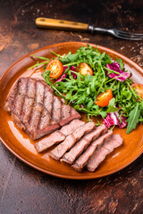 Grilled Australian Oyster Top blade steak with salad on a plate. brown background. top view