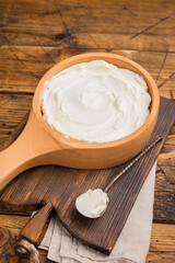 Italian Mascarpone cheese, cream cheese for tiramisu. wooden background. top view