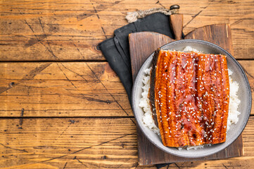 Unagi don or Japanese grilled eel rice in a bowl. wooden background. top view