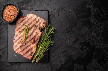 Grilled pork neck steaks. black background. top view