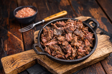 Traditional Barbecue smoked beef meat, pulled beef in a skillet. wooden background. top view