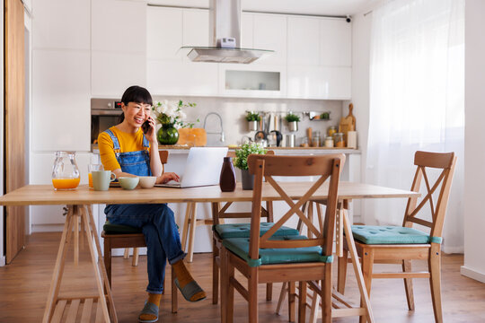 Woman working remotely from home having phone conversation using smart phone
