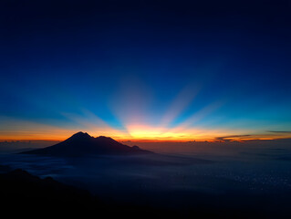 Dramatic Mountain Peak Silhouette at Colorful Sunrise with Golden Light