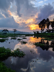 Serene Sky Reflection on Water at Sunrise, Dramatic Clouds