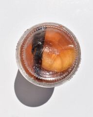 Upside down jar with peaches in syrup on white background top view