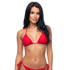 Fototapeta premium A stunning brunette model with long hair poses in a black swimsuit, her slim and fit body highlighting the glamour of the fashion shoot