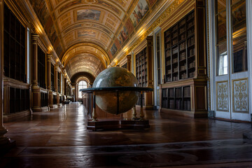 Antique globe bathed in soft daylight inside Fontainebleau’s grand library, highlighting regal architecture, historic bookshelves and the timeless allure of exploration.