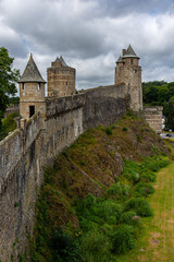 Close up view of the massive medieval curtain walls of Fougères Castle in Brittany, France, showcasing its defensive architecture and stone construction.