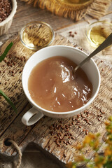 A cup of homemade flax seed gel, argan oil, apple cider vinegar - ingredients for natural diy shampoo. Alternative haircare, no poo.