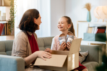 Mother and daughter are unpacking cardboard