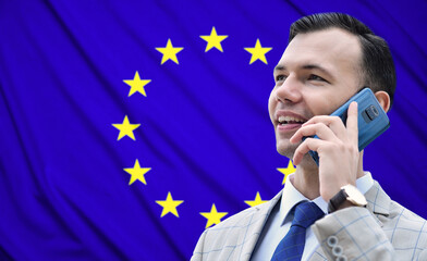 Happy businessman talking on smartphone on a EU flag background