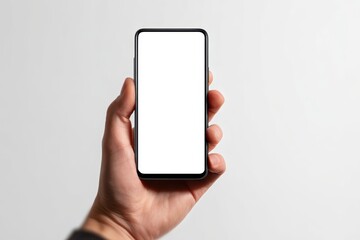 A hand grips a smartphone featuring a blank chromakey display representing technology and advertising captured in a detailed studio shot against a blurred white backdrop