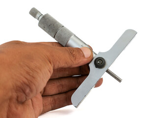 A person's hand holds a depth micrometer, a precision measuring tool, against a pure white...