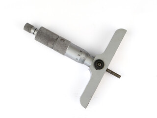 Top view of a depth micrometer on a white background. The silver and metallic gray precision measuring tool is shown at an angle, highlighting its scale and design.