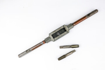 Fototapeta premium Top view a metal tap wrench and two separate steel taps are laid out on a clean white surface.